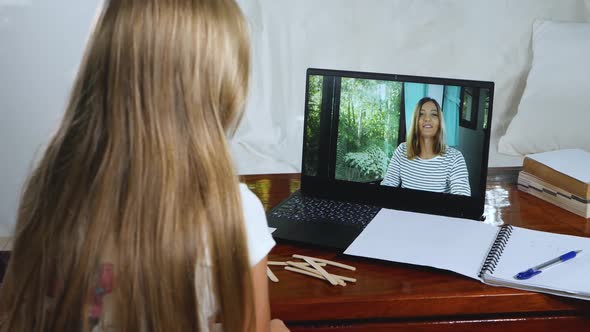 Child Little Girl Does Lesson's Homework Online at Home