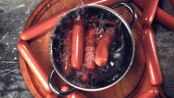 Super Slow Motion a Bunch of Sausages with Spray Falls Into a Pot of Water alt
