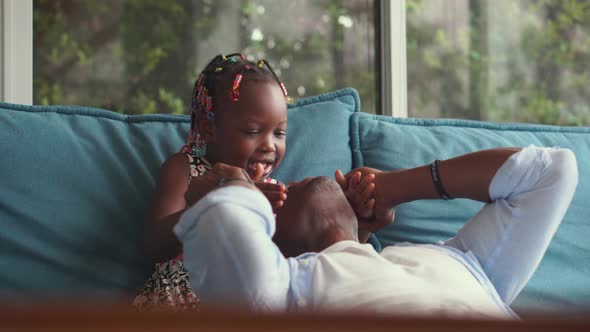 African American father and daughter playing in living room, Girl kissing her dad, Happiness family