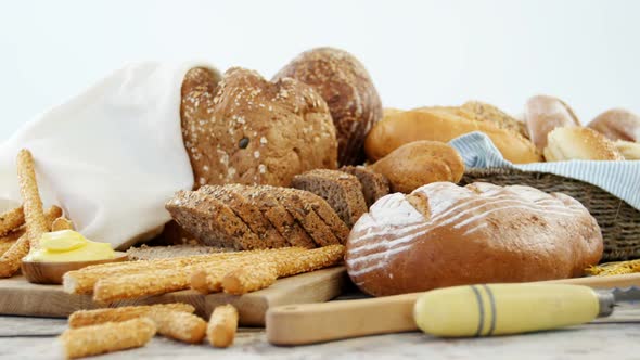 Various bread loaves on wooden table alt