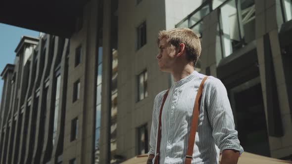 Man Standing Outdoors Business Building on the Background alt