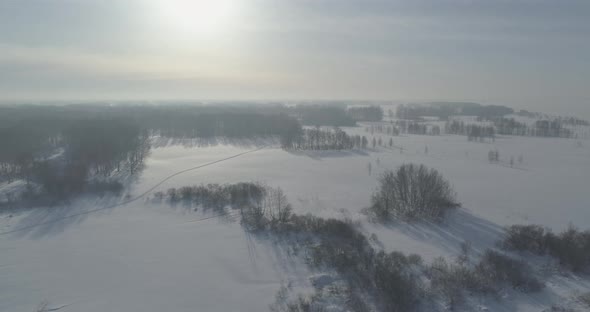 Aerial View of Cold Winter Landscape Arctic Field Trees Covered with Frost Snow Ice River and Sun alt