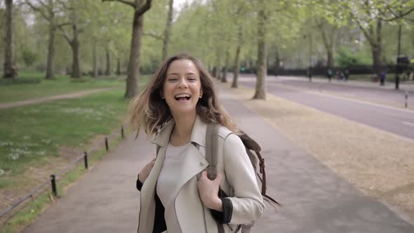 Happy woman walking in a park in London, UK