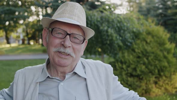 Portrait of Happy Senior Man Telling with Facial Expressions Into the Camera alt