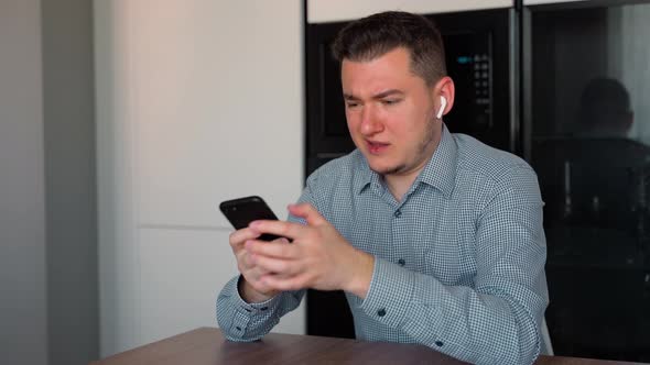 Caucasian business man developer receiving bad news on smartphone indoors alt