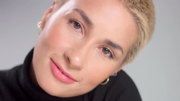 Blonde with Short Haircut in Studio Poses for Camera on Grey Ideal Skin alt