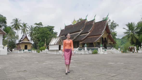 Beautiful Asian Girl Walking At Wat Xieng Thong Landmark In Luang Prabang alt