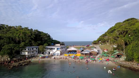 Aerial establishing shot of the Praia da Sepultura and the sea on both sides of a hill alt
