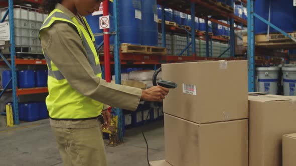 Young female worker using barcode scanner in a warehouse alt