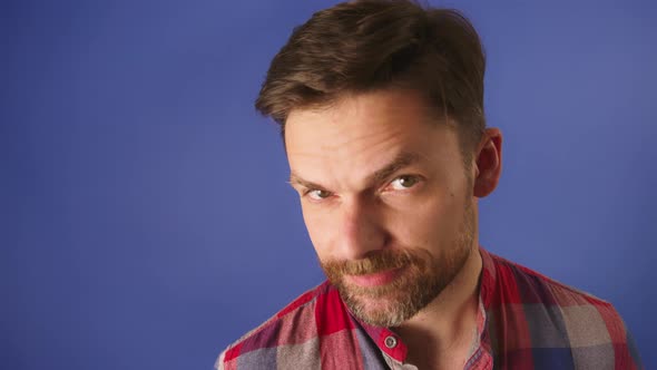 Flirty Face Expression of Young Bearded Caucasian Man. Portrait Isolated on Blu Background alt