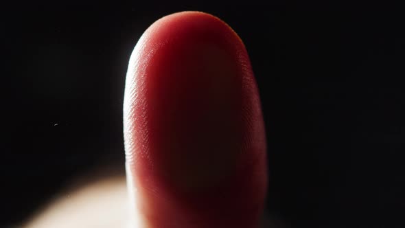 Human Hand Making Thumb Fingerprint on Black Background alt
