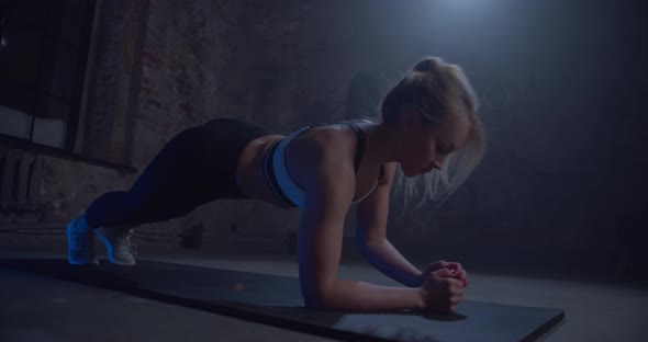 Strong Blonde Woman Exercising on the Floor at Urban Gym