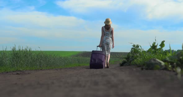 Cheerful Girl with Suitcase Walking on Road