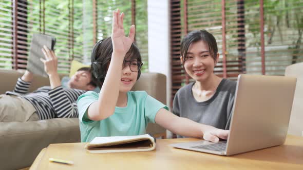 cheerful asian child boy online lesson study from home concept,asian child hand up for answer