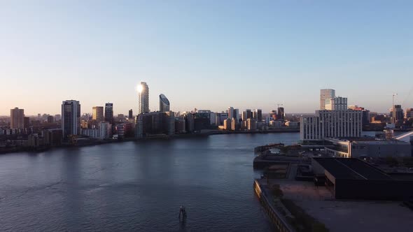 Aerial panoramic shot ofr Canary Wharf district with high-rise buildings, calm River Thames and o2 a alt