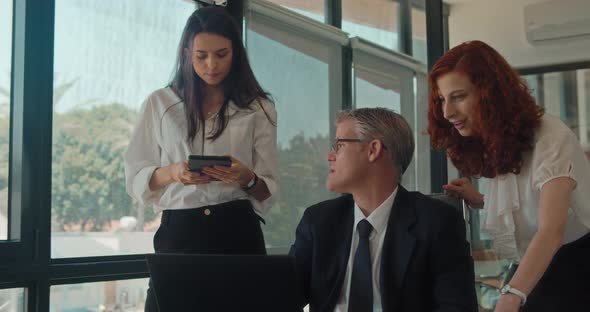 Group of people discuss a project using a computer at workplace. Business meeting, Slow motion