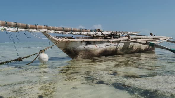 Old Dry African Fishing Rowboat Stranded in Sand on Beach at Low Tide Zanzibar alt