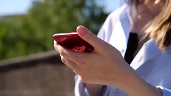Female hands touching smartphone outdoor. Unrecognizable woman using mobile phone alt