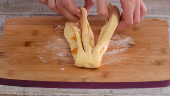 Female Hands Braiding a Dough