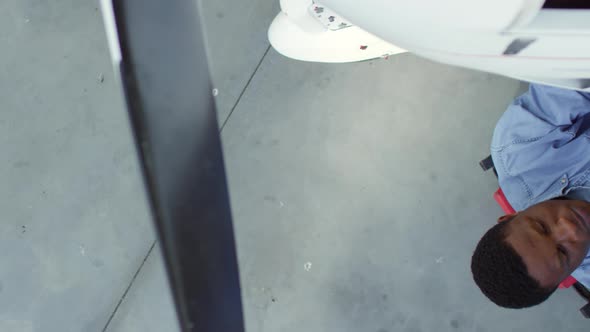 Black Mechanic Repairing Aircraft in Hangar alt