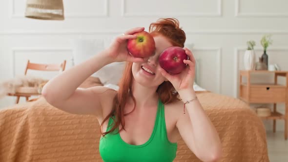 Woman Sitting on Floor with Apples in Hands alt