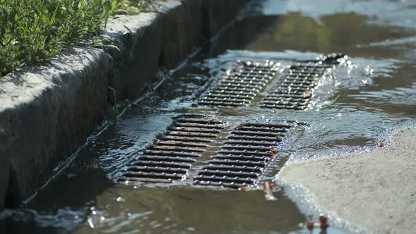 Water flows into the storm drain after damage to the water supply pipes.