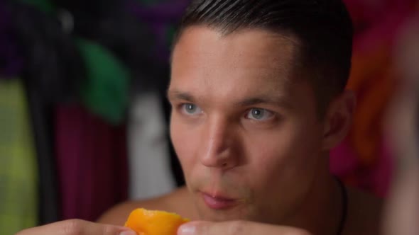 Young Man Greedily Eats Orange