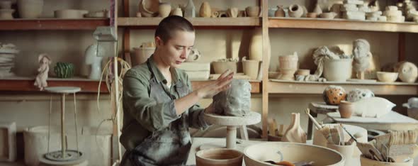 Female Artist Sculpting Clay Head in Workshop alt
