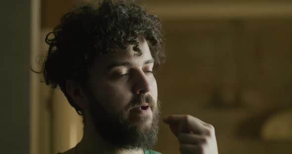 Portrait of a Young Bearded Caucasian Man Taking Vitamins