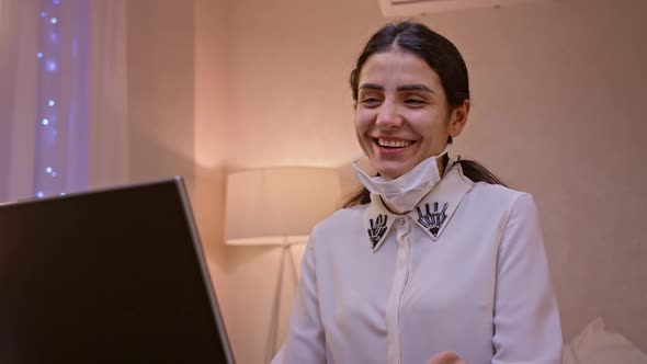 Young Business Woman in Face Mask Communicating By Video Call on Laptop Computer