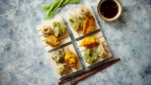 Delicious Mixed Kinds of Chinese Dumplings Served on Wooden Stands alt