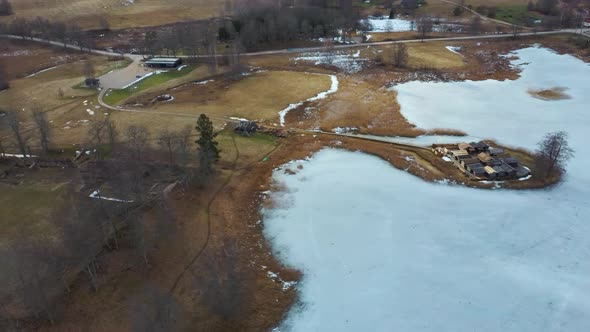 Historical Wooden Buildings on Small Island in the Frozen Lake Araisi in the Winter alt
