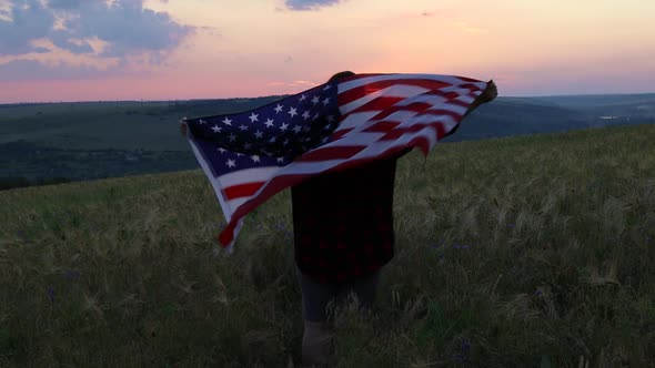 Happy Woman Standing with Her Back on Sunset in Nature Iwith Open Hands with USA Flag