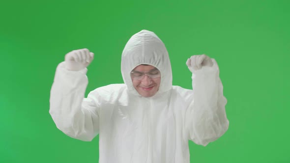 Asian Male Wearing Personal Protective Equipment Uniform Ppe And Dancing In Green Screen Studio alt