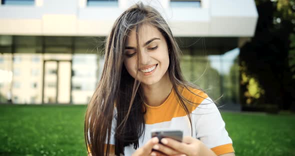 Smiling Woman Texting on Smartphone