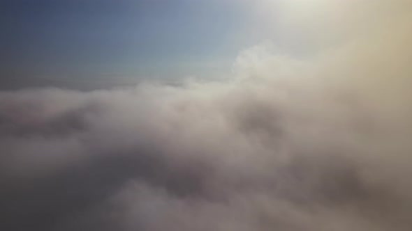 Aerial View From Airplane Window at High Altitude of Earth Covered with White Puffy Cumulus Clouds alt