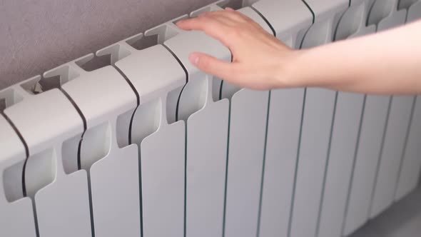 Woman's Hand Touches the Radiator alt
