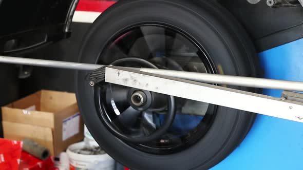 Set up a balancing center. Process of balancing and fitting car tire wheel in motion.