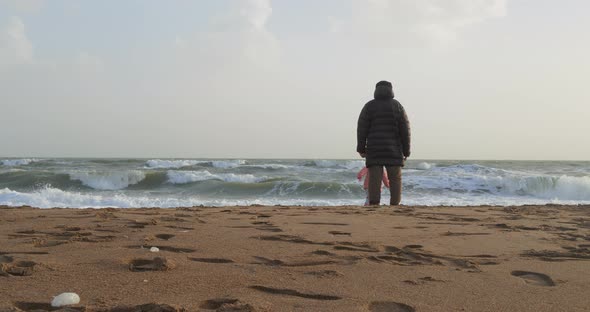 Young Girl Playing By the Sea with Her Grandfather