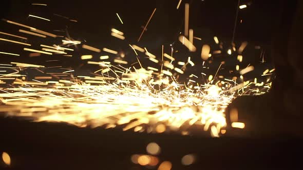 Close up construction worker cutting steel beam. Hot metal sparks.