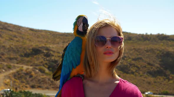 Parrot Playing with Coin in its Mouth While on Females Shoulder alt