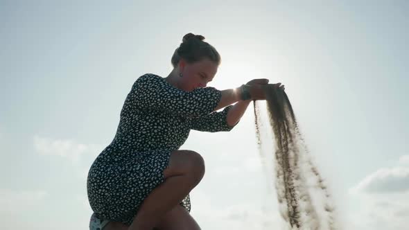Slow Motion a Young Girl Wearily Falls on Her Knees on the Sand alt