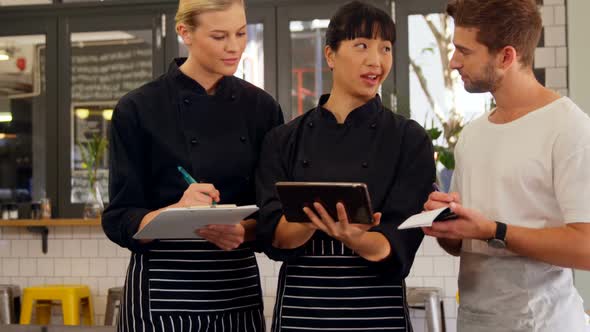 Waiter and waitress writing order in notepad 4k alt