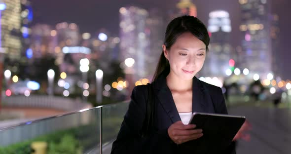 Asian Businesswoman use of tablet computer at night alt