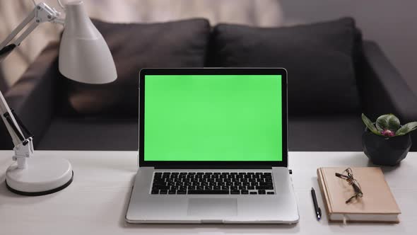Notebook With Green Screen for Chroma Key Technology Zooming Shot on Table in Living Room