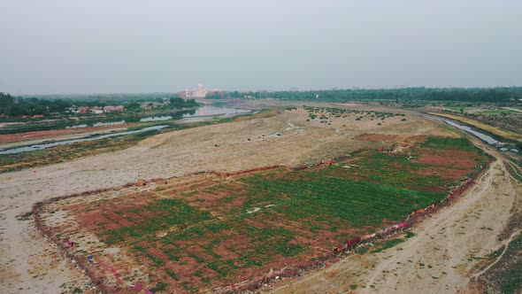 Aerial Ascending Shot of Taj Mahal Being Revealed and River Yamuna Flowing Alongside in Agra , Uttar alt