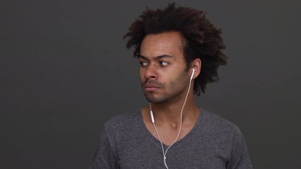 African American Young Man Listening to the Music with Headphones Then Taking It Off and Smiling alt