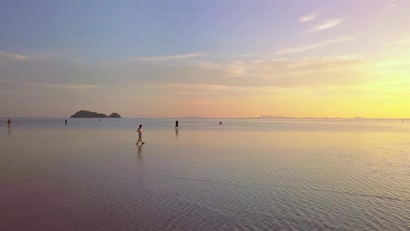 Young Woman Walking Alone on the Water In the Sea at Beautiful Sunset Thailand alt