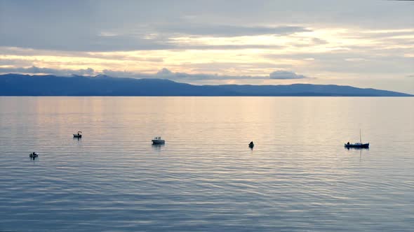 Small Fishing Boats On Calm Sea At Sunset