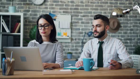 Cinemagraph Loop of Man Moving Pen in Hand Working in Office with Woman alt